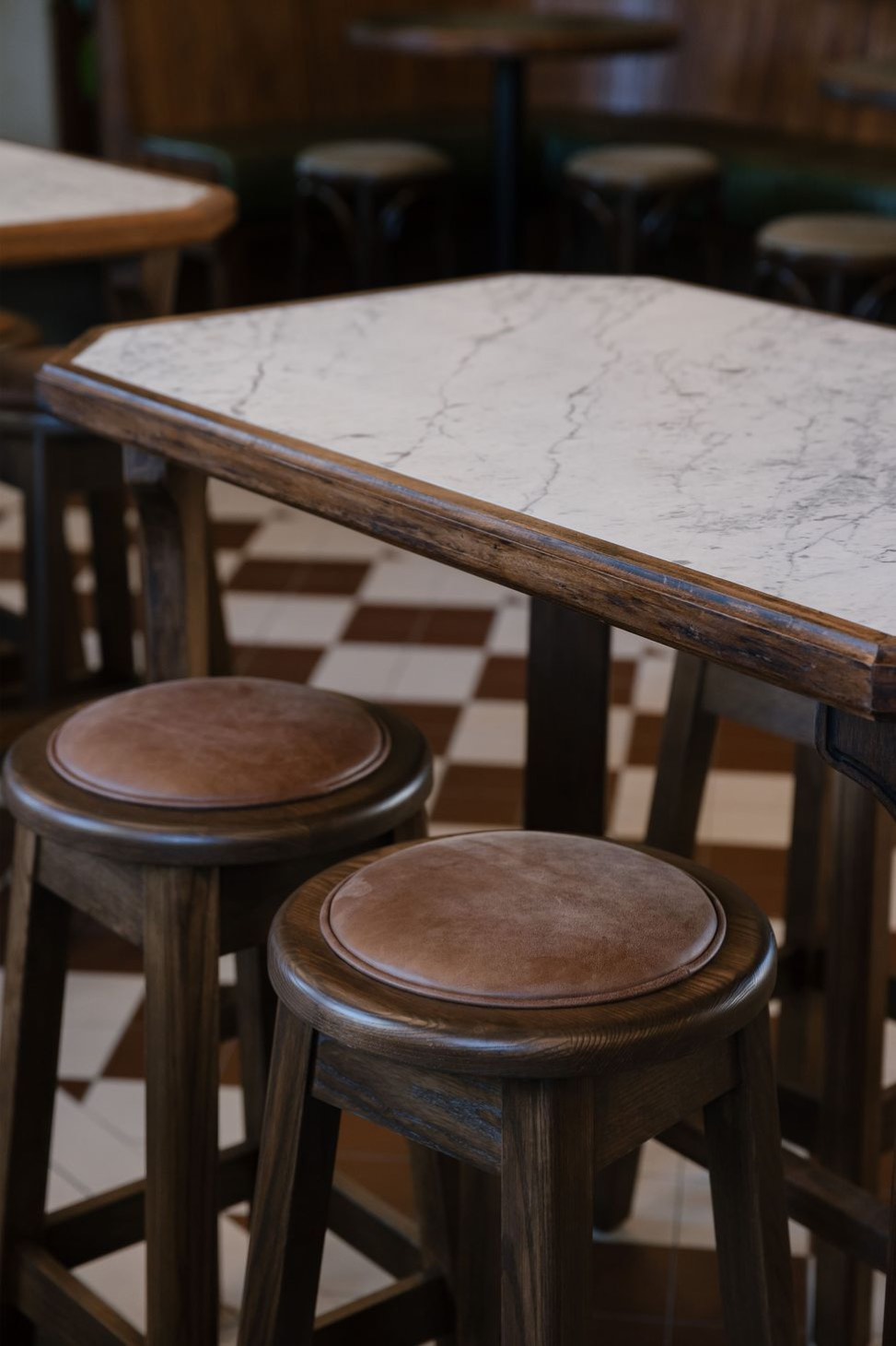Timber stools on the chequered tile floor