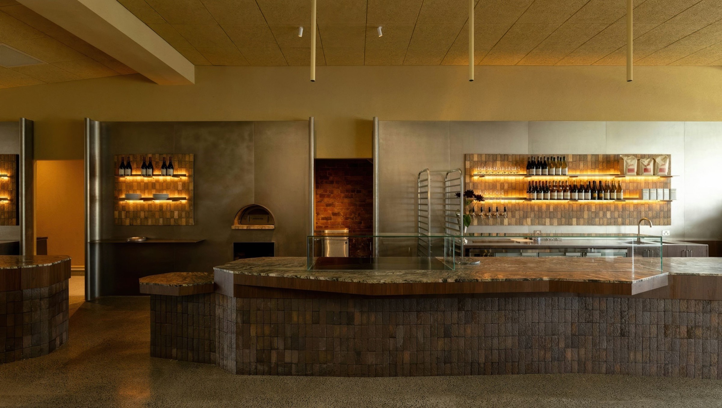 Mother's long stone counter with the bakery and wine shelves behind