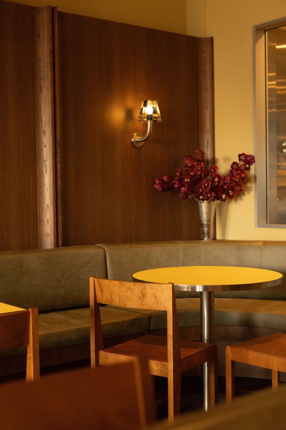 A butter-yellow table against walnut panelling